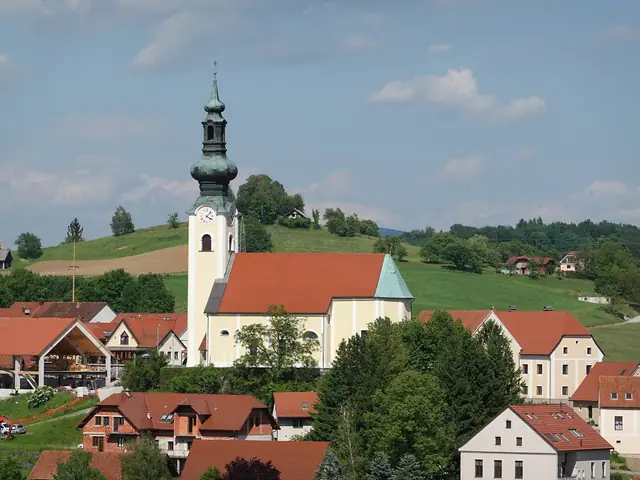 Začasna fotografija: cerkev v Šentjurju nad strehami mesta